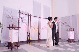 the newly weds standing against the fine japanese screens dad made for the wedding